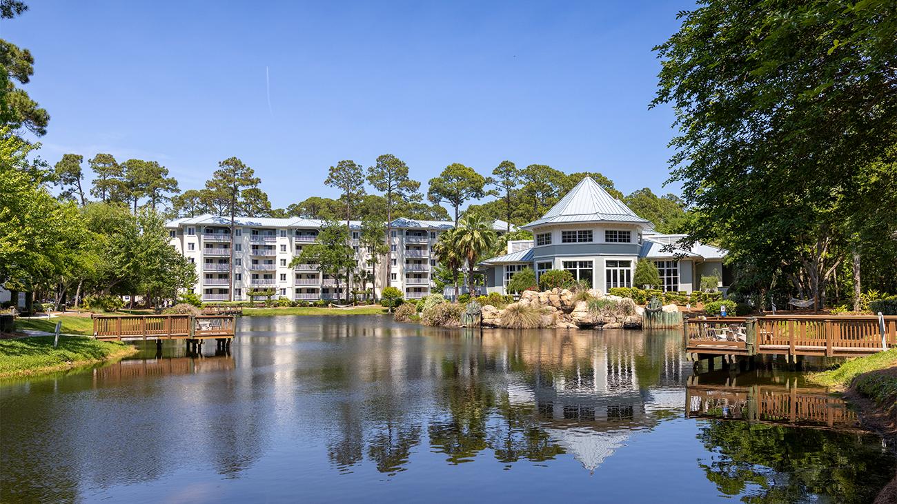 Exterior and pine forest grounds of Marriott's SurfWatch resort timeshare with pond and decks in the foreground